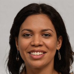 Joyful latino young-adult female with long  brown hair and brown eyes