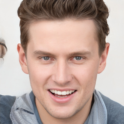 Joyful white young-adult male with short  brown hair and grey eyes