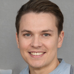 Joyful white young-adult male with short  brown hair and grey eyes