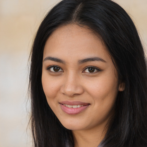 Joyful latino young-adult female with long  brown hair and brown eyes