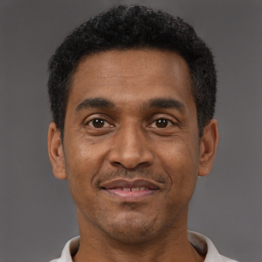 Joyful black adult male with short  brown hair and brown eyes
