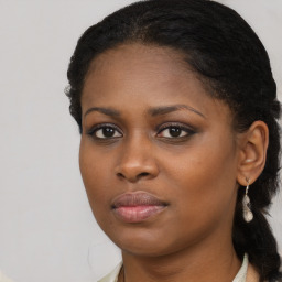 Joyful black young-adult female with long  brown hair and brown eyes