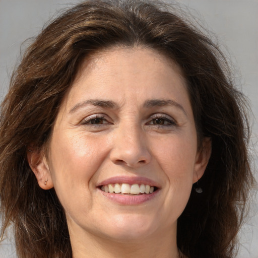 Joyful white adult female with long  brown hair and brown eyes