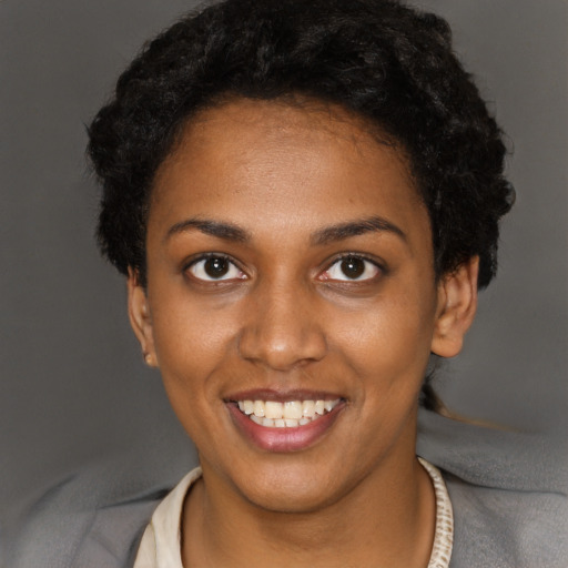 Joyful black young-adult female with short  black hair and brown eyes