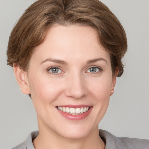 Joyful white young-adult female with short  brown hair and grey eyes