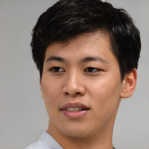 Joyful asian young-adult male with short  brown hair and brown eyes