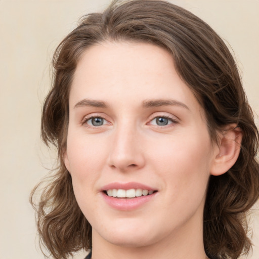 Joyful white young-adult female with medium  brown hair and green eyes