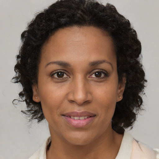 Joyful black adult female with short  brown hair and brown eyes