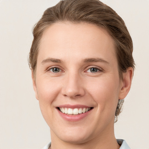 Joyful white young-adult female with short  brown hair and grey eyes