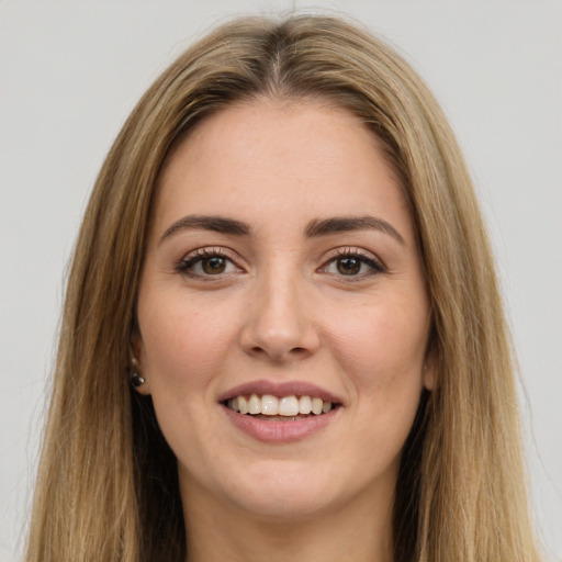 Joyful white young-adult female with long  brown hair and brown eyes