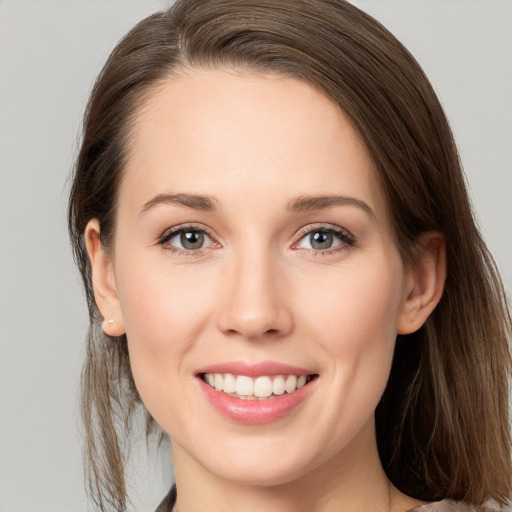 Joyful white young-adult female with long  brown hair and grey eyes