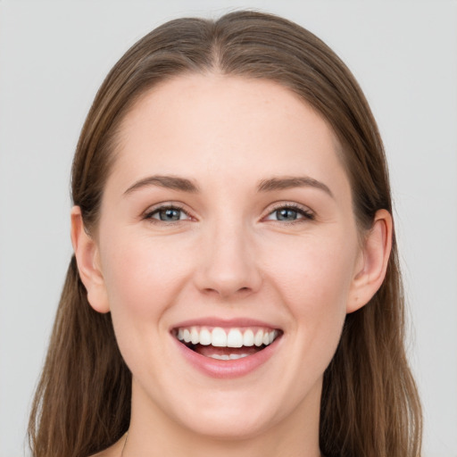 Joyful white young-adult female with long  brown hair and blue eyes