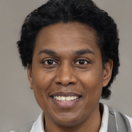 Joyful black adult male with short  black hair and brown eyes