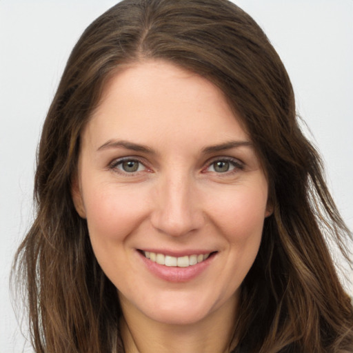 Joyful white young-adult female with long  brown hair and brown eyes