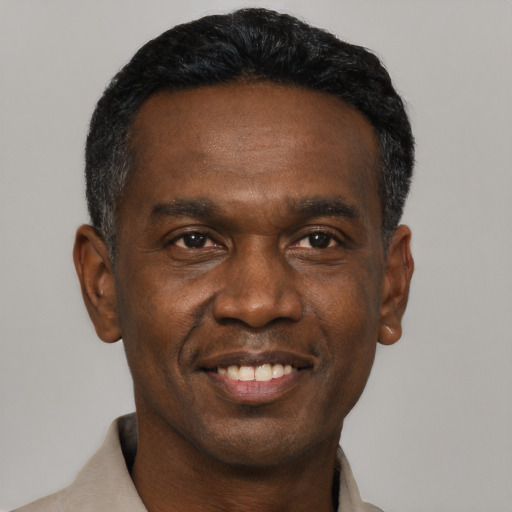 Joyful black adult male with short  black hair and brown eyes