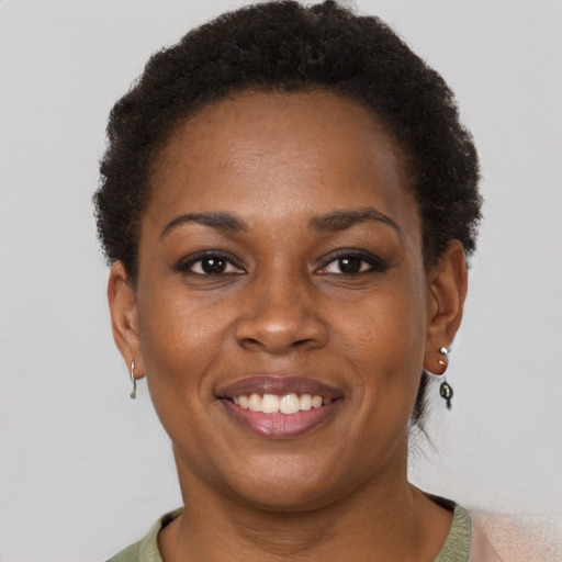 Joyful black young-adult female with short  brown hair and brown eyes