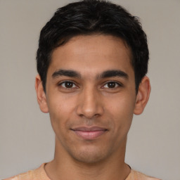 Joyful latino young-adult male with short  black hair and brown eyes