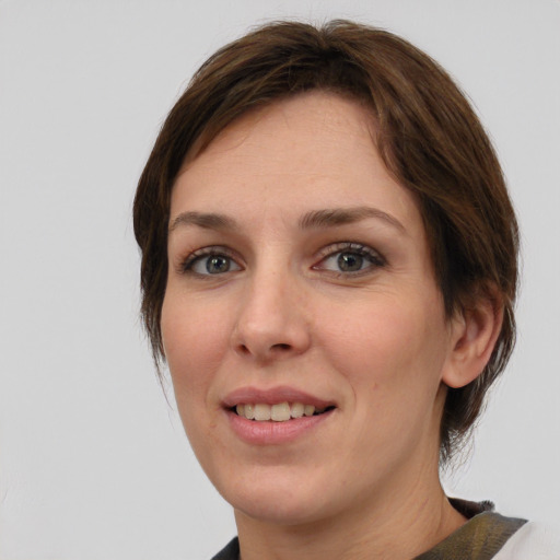 Joyful white young-adult female with medium  brown hair and green eyes