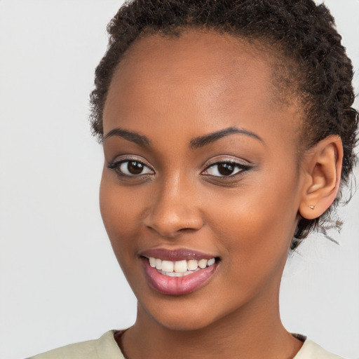 Joyful black young-adult female with short  brown hair and brown eyes