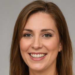 Joyful white young-adult female with long  brown hair and green eyes