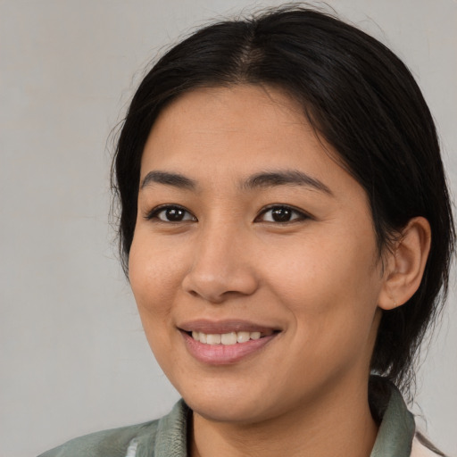 Joyful asian young-adult female with medium  black hair and brown eyes