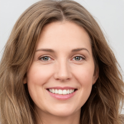 Joyful white young-adult female with long  brown hair and green eyes