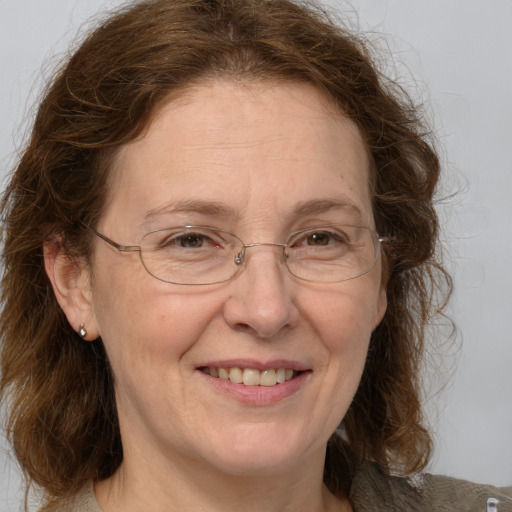 Joyful white middle-aged female with medium  brown hair and grey eyes