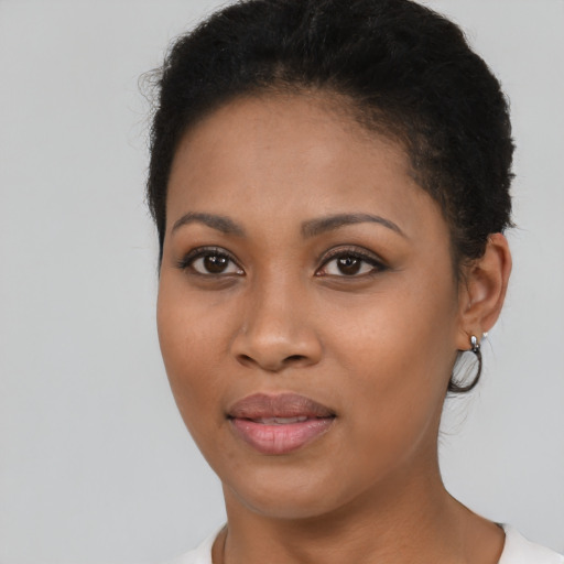 Joyful black young-adult female with short  brown hair and brown eyes