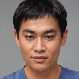 Joyful asian young-adult male with short  black hair and brown eyes