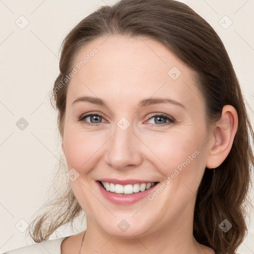 Joyful white young-adult female with medium  brown hair and grey eyes