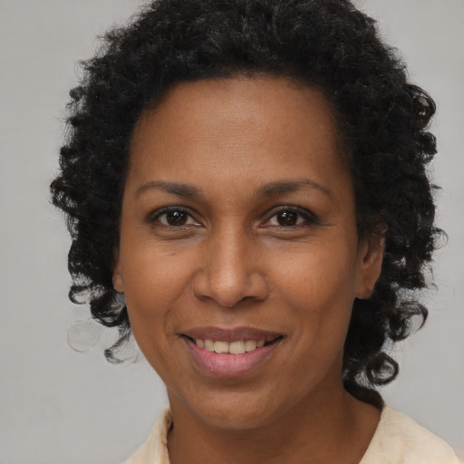 Joyful black adult female with long  brown hair and brown eyes