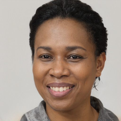 Joyful black adult female with short  black hair and brown eyes