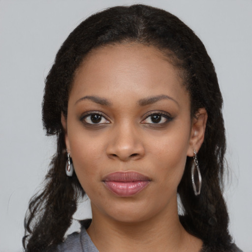 Joyful black young-adult female with long  black hair and brown eyes