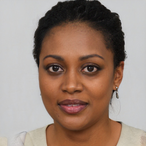 Joyful black young-adult female with short  black hair and brown eyes