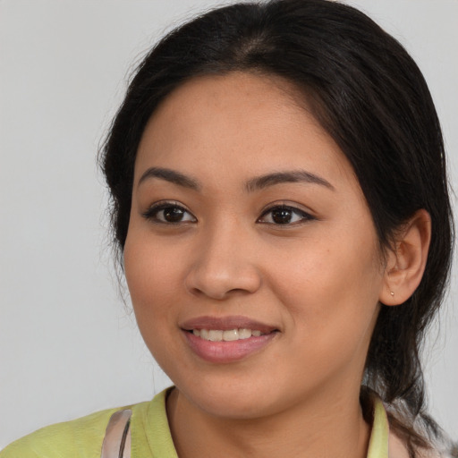 Joyful latino young-adult female with medium  brown hair and brown eyes