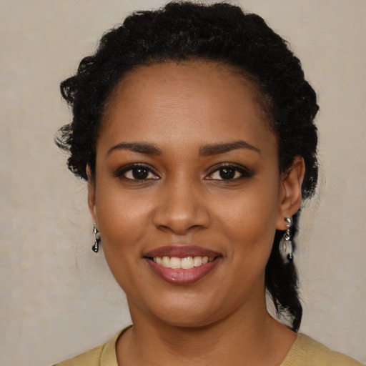 Joyful black young-adult female with long  black hair and brown eyes