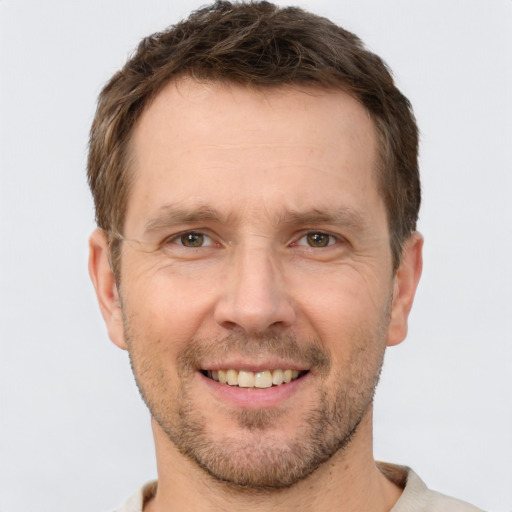 Joyful white adult male with short  brown hair and brown eyes