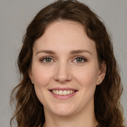 Joyful white young-adult female with long  brown hair and green eyes