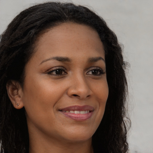 Joyful black young-adult female with long  brown hair and brown eyes