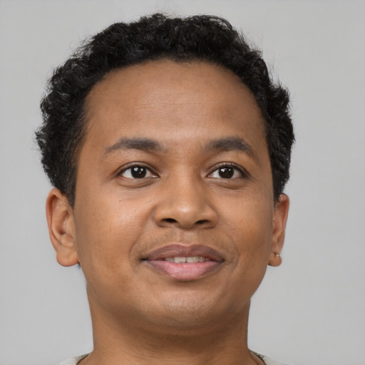 Joyful latino young-adult male with short  brown hair and brown eyes