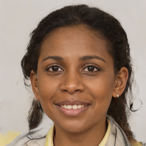 Joyful black young-adult female with medium  brown hair and brown eyes