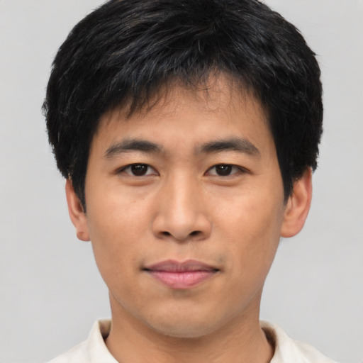 Joyful asian young-adult male with short  black hair and brown eyes