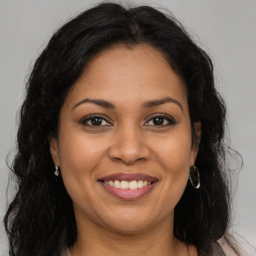 Joyful latino adult female with long  brown hair and brown eyes