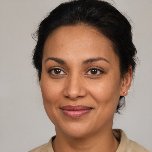 Joyful latino adult female with medium  brown hair and brown eyes