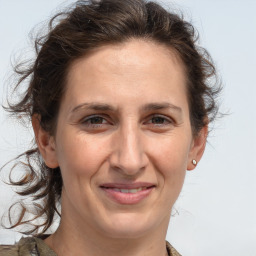 Joyful white adult female with medium  brown hair and grey eyes