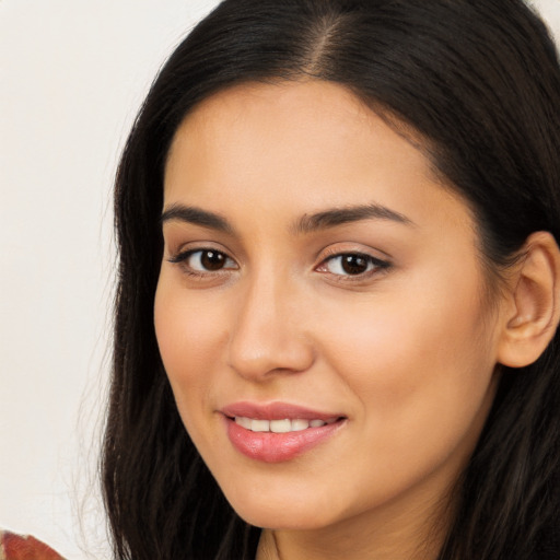 Joyful latino young-adult female with long  brown hair and brown eyes