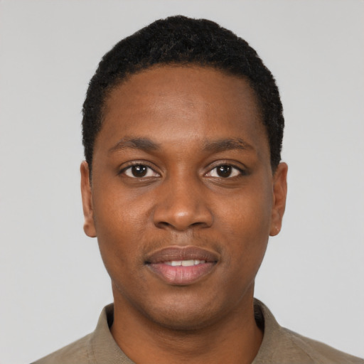 Joyful black young-adult male with short  black hair and brown eyes