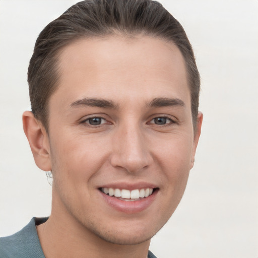 Joyful white young-adult male with short  brown hair and grey eyes