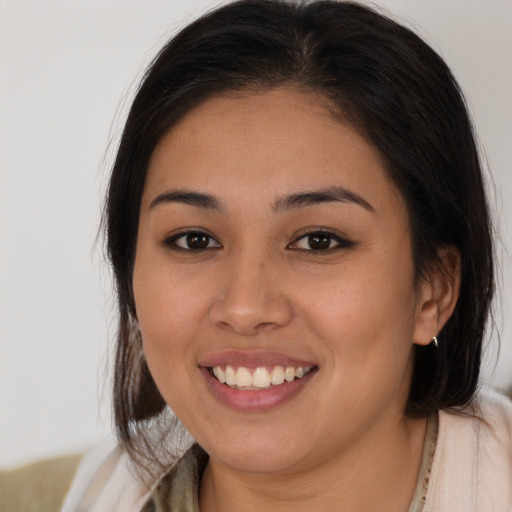 Joyful latino young-adult female with medium  brown hair and brown eyes