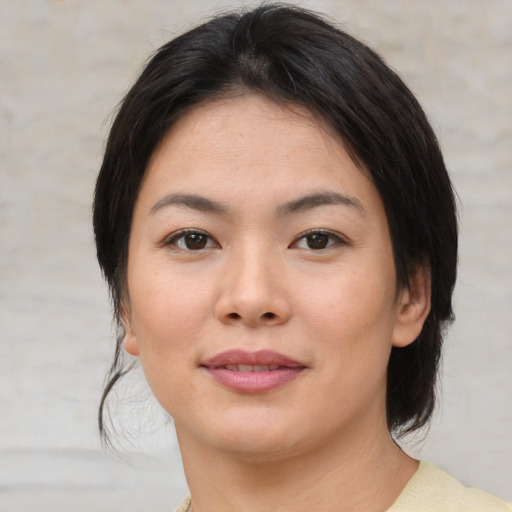 Joyful asian young-adult female with medium  brown hair and brown eyes